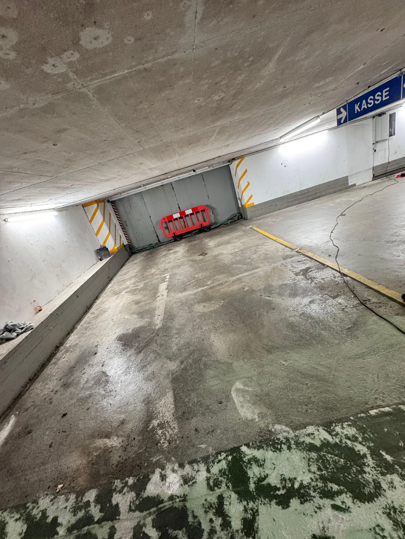 Tiefgaragenrampe vor der Beschichtung: Die alte grüne Beschichtung ist teilweise abgetragen, der Beton fleckig und verschmutzt.