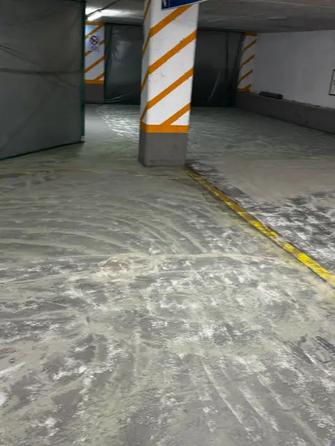 Stellplatzbereich einer Tiefgarage nach dem Abschleifen des alten Belags: Der Betonuntergrund ist für die neue Beschichtung vorbereitet.