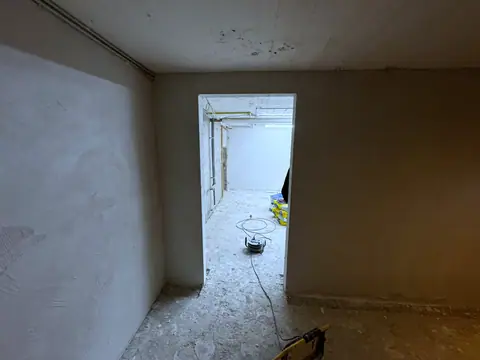 Derselbe Kellerraum mit neuem Sanierputz, Blick durch die Tür in den Nebenraum.