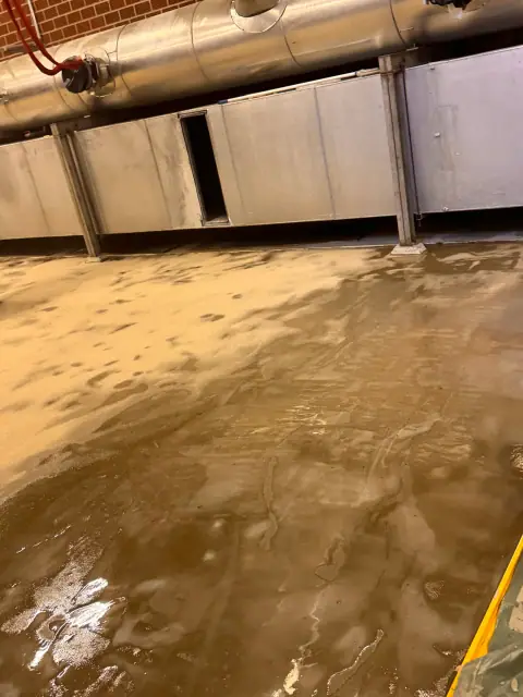 Nasse Grundierung auf dem Hallenboden, teilweise schon mit Quarzsand abgestreut.